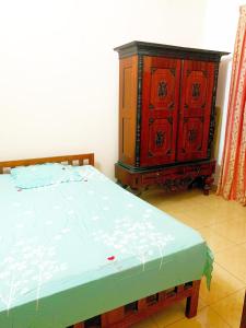 a bedroom with a bed and a wooden dresser at Matara Near Polhena & Mirissa Three Story House in Matara
