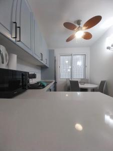 una cucina con bancone bianco e ventilatore a soffitto di Villa Supranee 1 a Câmara de Lobos
