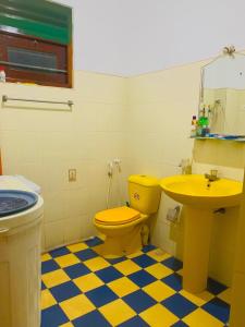 a bathroom with a yellow toilet and a sink at Matara Near Polhena & Mirissa Three Story House in Matara