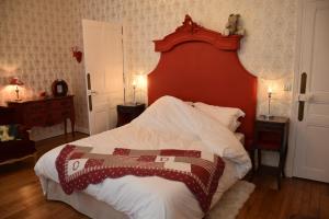 een slaapkamer met een groot bed met een rood hoofdeinde bij La Porte De Bretagne in Péronne