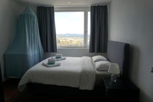 um quarto com uma cama e uma janela com duas chávenas em Switzerland Suite im 12. Stock em Thun