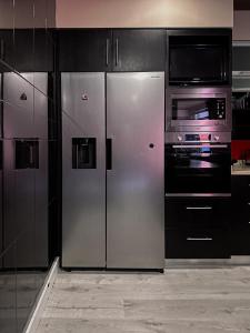 uma cozinha com um frigorífico de aço inoxidável e um micro-ondas em Bem Viver Country House em Favões