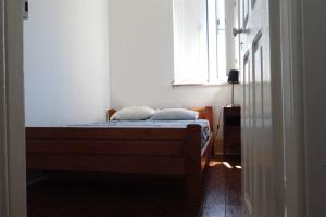 ein Schlafzimmer mit einem Bett in einem Zimmer mit einem Fenster in der Unterkunft Vivenda Costa in Tondela