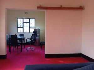 Boma la NgombeにあるAirb&b Homestayのテーブルと椅子が備わる壁の客室です。