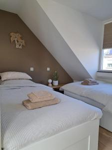 2 Betten mit Handtüchern in einem Schlafzimmer in der Unterkunft Bundi Beach in Egmond aan Zee