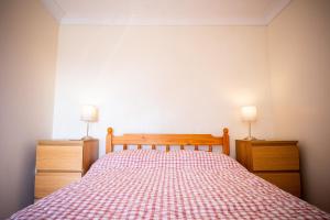 een slaapkamer met een bed met een rode en witte sprei bij Pen-Y-Graig Cottage Brynamman in Brynamman