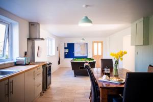 a kitchen with a table and a kitchen with a pool table at Pen-Y-Graig Cottage Brynamman in Brynamman