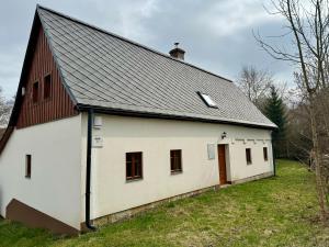 Biała stodoła z czarnym dachem w obiekcie V Údolí w mieście Jablonné v Podještědí