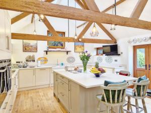 a kitchen with white counters and wooden beams at Walnut Studio - Horsham in Horsham