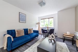 a living room with a blue couch and a table at The Peckham Collection in London