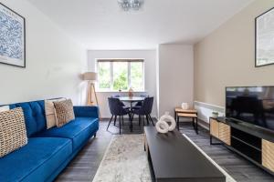 ein Wohnzimmer mit einem blauen Sofa und einem Tisch in der Unterkunft The Peckham Collection in London