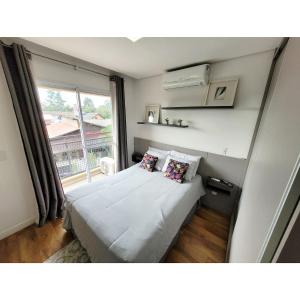 een kleine slaapkamer met een bed en een raam bij Studio Completo Cotia Granja Vianna 417 in Cotia