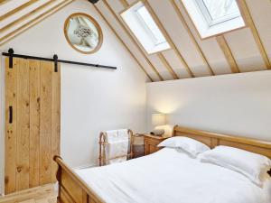 a bedroom with a bed with skylights and a ceiling at Walnut Studio - Horsham in Horsham