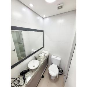 een badkamer met een wastafel, een toilet en een spiegel bij Studio Completo Cotia Granja Vianna 417 in Cotia