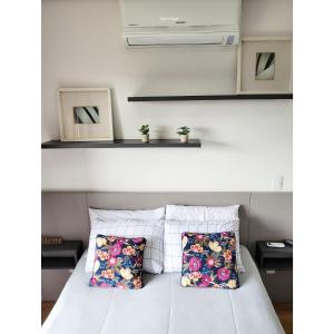 een slaapkamer met een wit bed met 2 kussens bij Studio Completo Cotia Granja Vianna 417 in Cotia