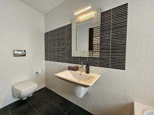 a bathroom with a sink and a toilet and a mirror at Malta Unique Penthouse Spacious Terrace-Sleeps 8 in Mġarr +22 photos