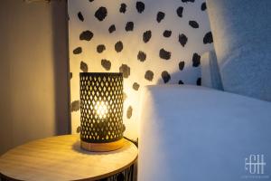 een lamp op een tafel naast een bed bij Le Picasso in Tours