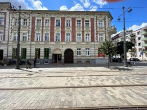 a large brick building on a city street at Chrobry pokój de luxe in Gorzów Wielkopolski