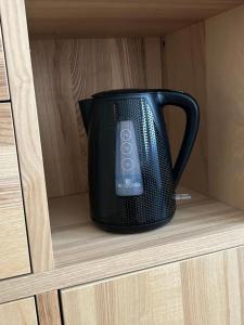 a black pot sitting on a shelf in a cabinet at Chrobry pokój de luxe in Gorzów Wielkopolski