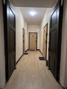 an empty hallway with doors and wooden floors at Chrobry pokój de luxe in Gorzów Wielkopolski