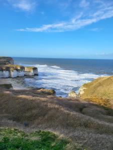 een uitzicht op een strand met de oceaan en rotsen bij 4-Bed Lodge in flamborough Bridlington sleeps 8 in Bridlington