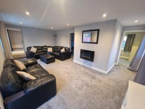 a living room with a leather couch and a television at 4-Bed Lodge in flamborough Bridlington sleeps 8 in Bridlington