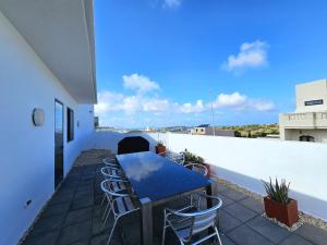 a patio with a table and chairs on a roof at Malta Unique Penthouse Spacious Terrace-Sleeps 8 in Mġarr