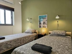 a hotel room with two beds and a window at Malta Unique Penthouse Spacious Terrace-Sleeps 8 in Mġarr