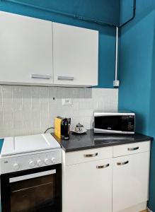 フェラーラにあるAMA Ferraraのキッチン(白いキャビネット、黒と白の電子レンジ付)