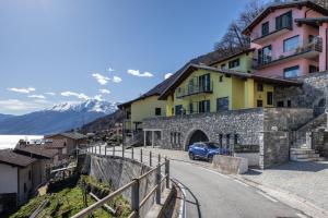 a blue car parked on a street next to buildings at LAGO DI COMO - Luxury Panoramic Garden - Free Wifi in Gera Lario