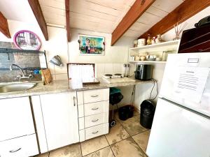 a kitchen with white cabinets and a sink and a refrigerator at MaBella in Richards Bay +15 photos