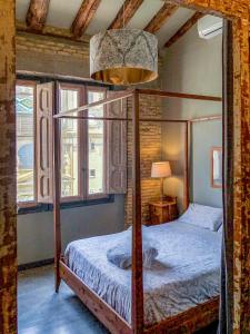a bedroom with a canopy bed and a lamp at Apartamentos Basilicus in Zaragoza