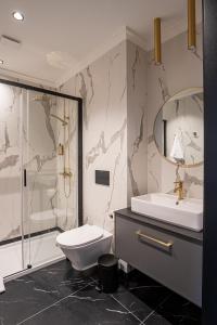 a bathroom with a toilet and a sink and a shower at Carvala Boutique Apartments in Częstochowa +104 photos