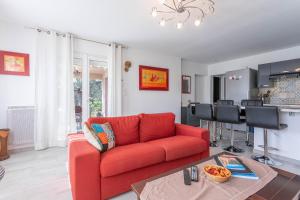 sala de estar con sofá rojo y mesa en Rez Villa 65m² 5 min centre plages, en Saint-Raphaël