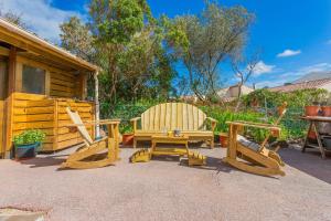 2 sillas, una mesa y un banco en un patio en Rez Villa 65m² 5 min centre plages, en Saint-Raphaël