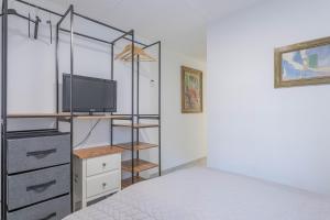 1 dormitorio con 1 cama, TV y vestidor en Rez Villa 65m² 5 min centre plages, en Saint-Raphaël