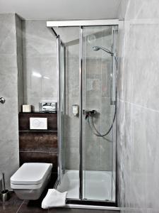 a bathroom with a shower and a toilet at Concorde Hotel Ascot in Düsseldorf