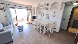 a living room with a white table and chairs at La Font Lovely apartment LEstartit 400 meter from the beach in L'Estartit