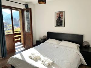 a bedroom with a large bed with white sheets at Traveller's home in the Dolomites in Porte di Rendena