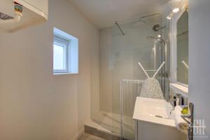 ein Bad mit einer Glasdusche und einem Waschbecken in der Unterkunft Le Scandinave in Tours