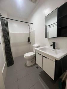 biała łazienka z toaletą i umywalką w obiekcie Deluxe Cozy Corner Studio w mieście Minglanilla