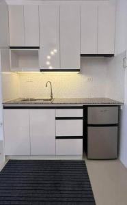 una cocina con armarios blancos y fregadero en Deluxe Cozy Corner Studio, en Minglanilla