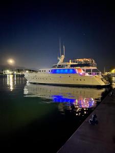 un bateau blanc assis dans l'eau la nuit dans l'établissement Cohete Boat, à Ameglia