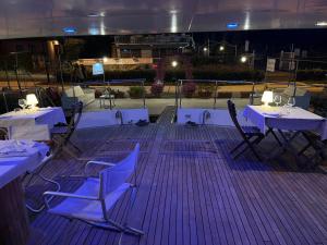dos mesas y sillas en una terraza por la noche en Cohete Boat, en Ameglia