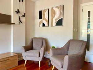 a living room with two chairs and a tv at Piso Vistas O Son in Cee