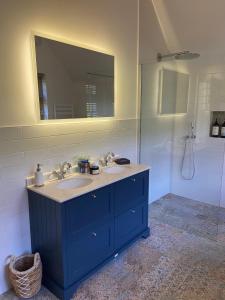 La salle de bains est pourvue d'un lavabo bleu et d'un miroir. dans l'établissement Luxury in the Lake District, à Dockray