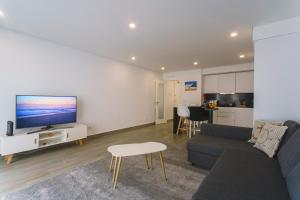 a living room with a couch and a tv at Best Houses 104 - Supertubos Beach Apartment in Atouguia da Baleia