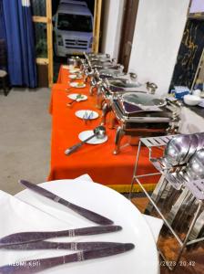 uma fila de mesas com pratos e utensílios em Tyakshi Summer Camp em Turtok
