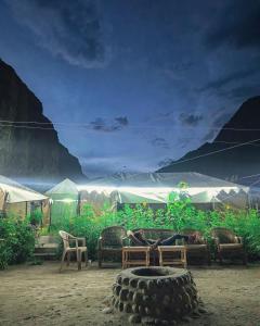 a tent with chairs and a table and a large tire at Tyakshi Summer Camp in Turtok