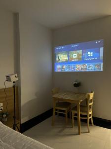 a room with a table and two chairs and a screen at Dodo home AC in Hanoi